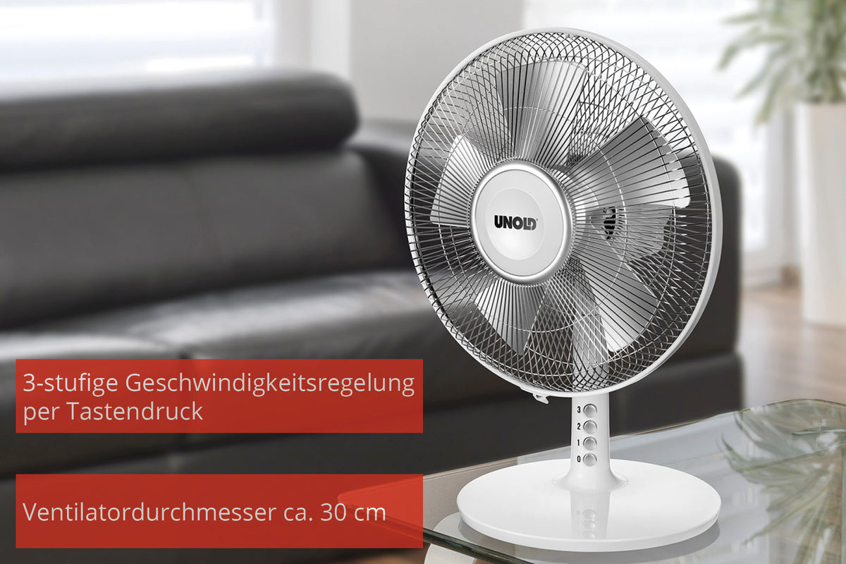 Der Unold TISCHVENTILATOR SILVERLINE 30 cm mit rundem Standfuß ist im Innenbereich abgebildet. Der Text hebt die 3-stufige Touch-Steuerung und den Ventilatordurchmesser von ca. 30 cm hervor. Der Hintergrund ist unscharf.