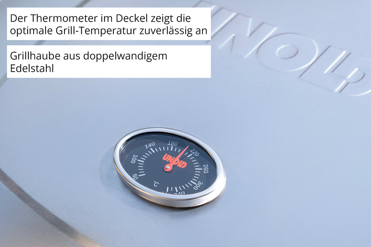 Nahaufnahme des Edelstahl-Grilldeckels mit integriertem Thermometer am Barbecue Grill-Wagen Buddy von Unold; daneben ein deutscher Hinweis zur Temperaturanzeige und Grillhaube.