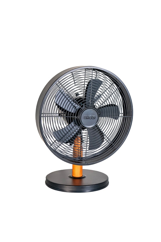 Der Unold Tischventilator Black Steel ist ein moderner schwarzer elektrischer Tischventilator mit rundem Sockel, Holzakzent am Ständer, Schutzgittern und fünf Flügeln, die isoliert auf weißem Hintergrund dargestellt sind.