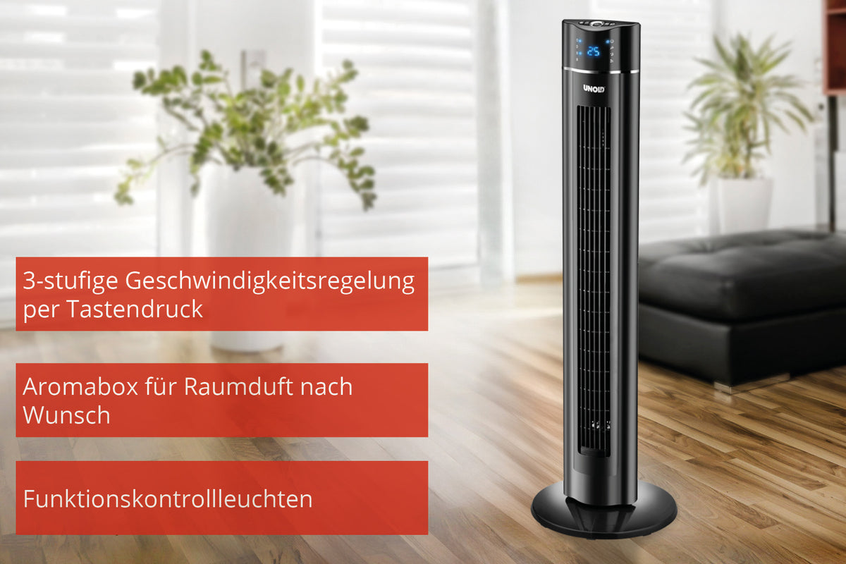 Der Unold TURMVENTILATOR SKYLINE, ein schwarzer Turmventilator, steht in einem modernen Wohnzimmer mit Holzboden. Er verfügt über eine 3-stufige Tastensteuerung, eine Aromabox für Duft und Funktionsleuchten. Im Hintergrund sind eine grüne Pflanze und ein schwarzes Sofa zu sehen.