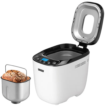 Ein geöffneter Brotbackautomat Unold 68010 Backmeister® Design mit Digitalanzeige gibt den Blick auf sein leeres Inneres frei, während daneben eine herausnehmbare Brotform ein frisch gebackenes Mehrkornbrot bereithält.