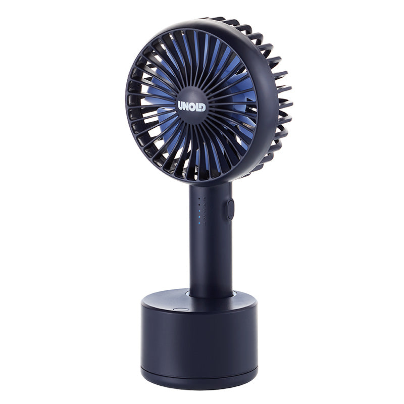 Der Unold HANDVENTILATOR BREEZY SWING ist ein kleiner, schwarzer Handventilator mit rundem Ventilatorkopf, zylindrischem Griff und rundem Standfuß. In der Mitte ist die Marke „Unold“ zu sehen, und der Ventilator steht aufrecht auf seinem Standfuß.